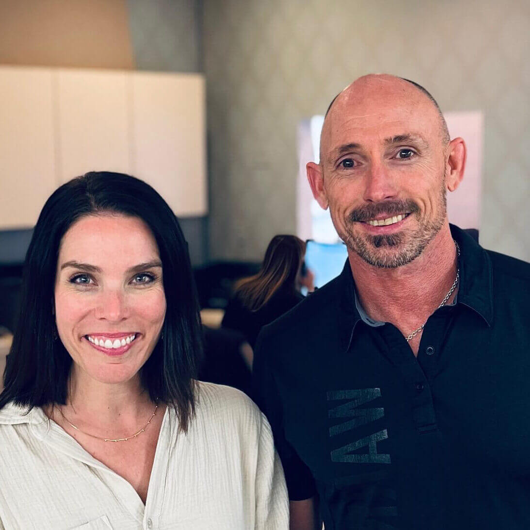 OrthoHeaven A woman and a man stand side by side indoors, smiling at the camera. The background—likely inside OrthoHeaven—shows blurred cabinets and another person working at a desk. Freedom Mapping