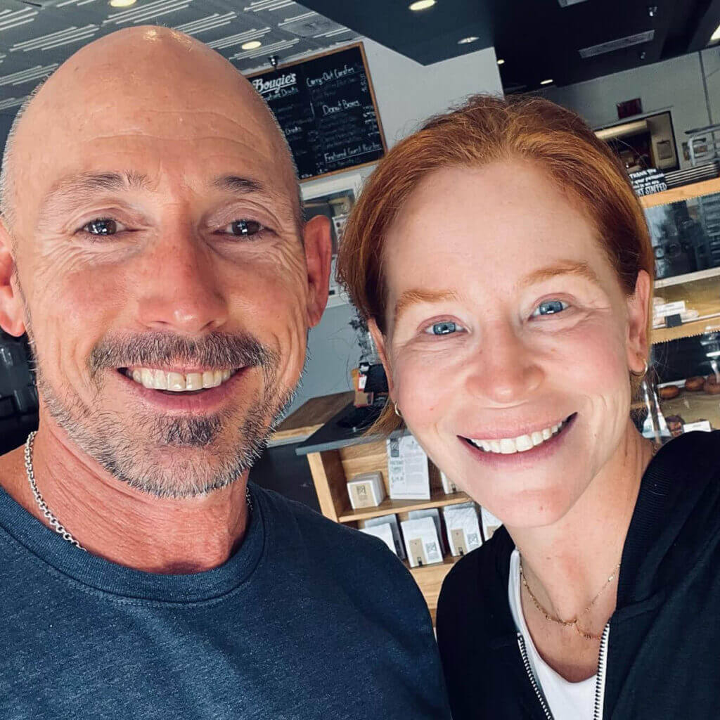 OrthoHeaven Two people smiling for a selfie inside a café or bakery, with a menu board and display case in the background—they’re showing off their OrthoHeaven smiles. Freedom Mapping